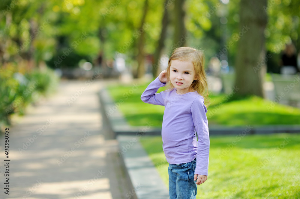 Cute little girl having fun outdoors on sunny summer evening. Child exploring nature. Cute little girl having fun outdoors on sunny summer evening. Child exploring nature.