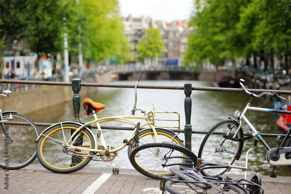 Bicycles parked on the bridge over canal in Amsterdam, Netherlands.