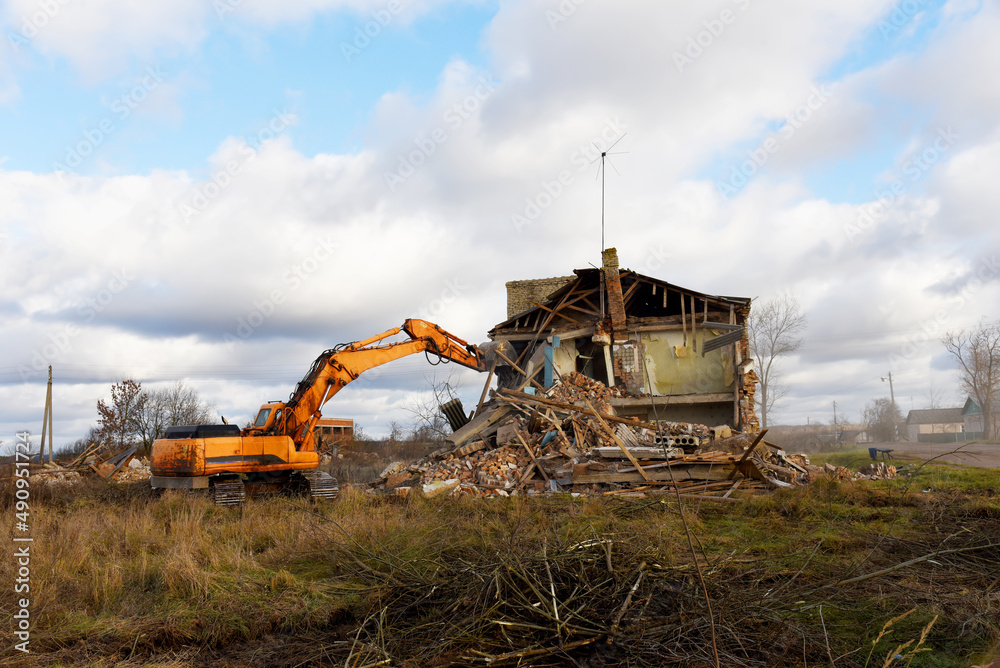 Excavator during demolition the house in the rural. Renovation old home
