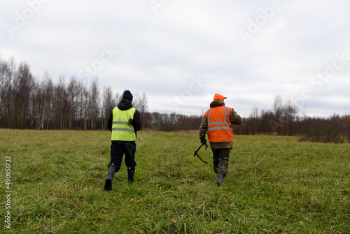 Hunter during hunting in forest. Hunter while hunting wild animals. Hunters with gun and rifle on hunting in the fall season. Hunters track down a wild boar or elk in the forest. Soft focus.