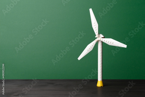 Fototapeta Naklejka Na Ścianę i Meble -  Model of wind turbine against dark green background. Ecology and Green energy concept. Eco-friendly, green power. Copy space