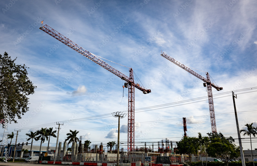 Two tall cranes and other construction equipment on site in Fort Lauderdale downtown district in South Florida