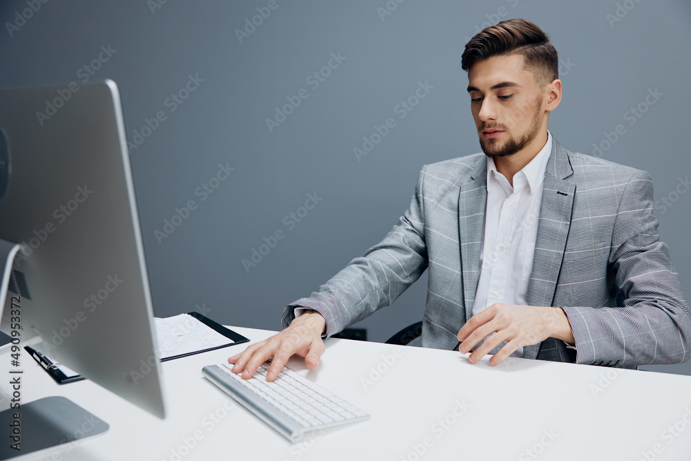 handsome man documents on the table computer work emotions Gray background handsome man documents on the table computer work emotions Gray background