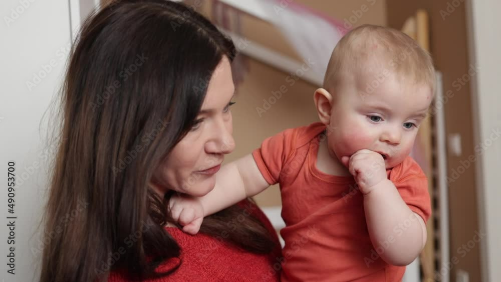 Young cheerful woman playing with her infant bay. Mother spending time with her baby. Motherhood Young cheerful woman playing with her infant bay. Mother spending time with her baby. Motherhood