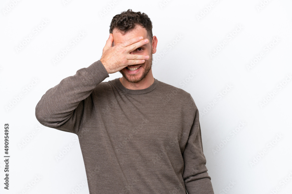 Young Brazilian man isolated on white background covering eyes by hands and smiling Young Brazilian man isolated on white background covering eyes by hands and smiling