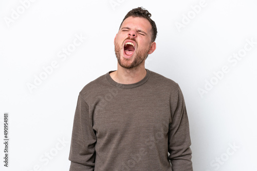 Young Brazilian man isolated on white background shouting to the front with mouth wide open © luismolinero