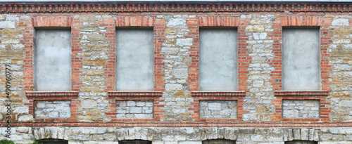 Old rustic house wall, with bricked up window.