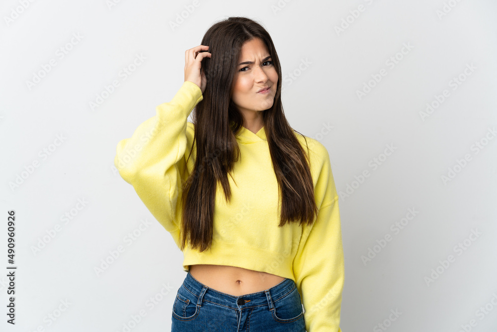 Teenager Brazilian girl isolated on white background having doubts Teenager Brazilian girl isolated on white background having doubts