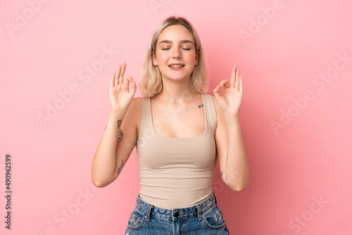 Young caucasian woman isolated on pink background in zen pose