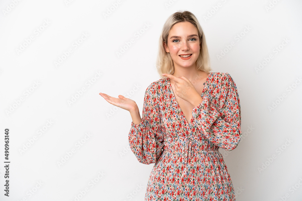 Young caucasian woman isolated on white background holding copyspace imaginary on the palm to insert an ad