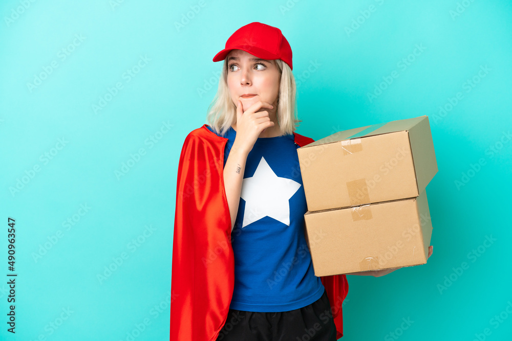 Super Hero caucasian delivery woman isolated on blue background having doubts and thinking Super Hero caucasian delivery woman isolated on blue background having doubts and thinking