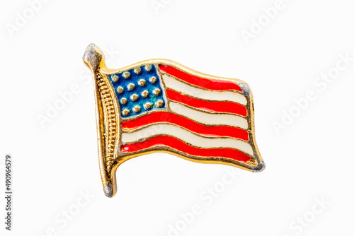 Antique enameled American flag pin on white background.