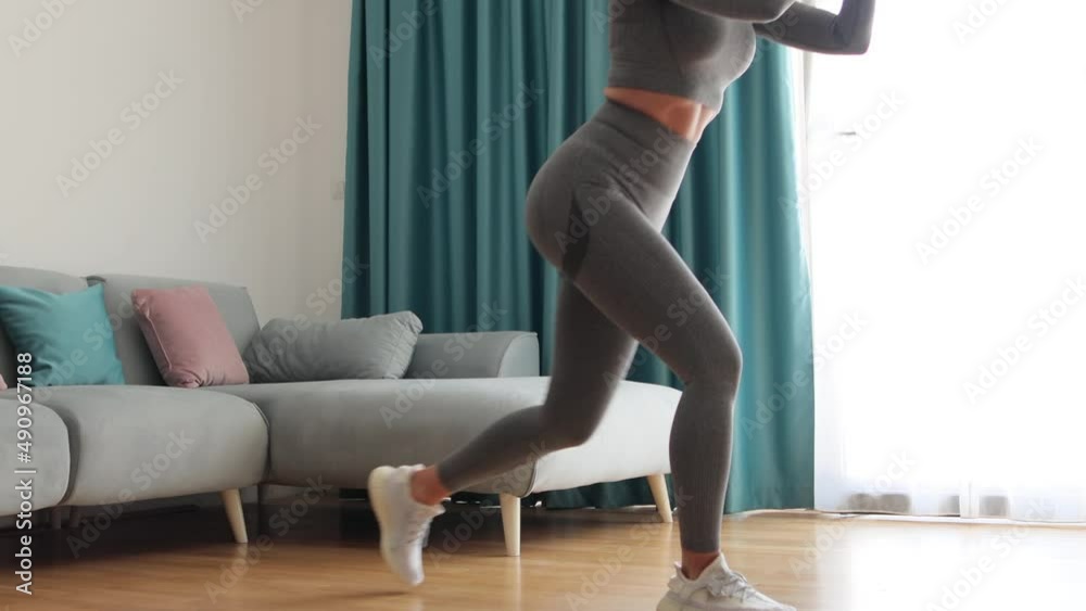 female butt workout squats at home. Athletic Woman squats workout in living room. Female gymnastics. Glutes workout motivation. Fitness at home concept. female butt workout squats at home. Athletic Woman squats workout in living room. Female gymnastics. Glutes workout motivation. Fitness at home concept.