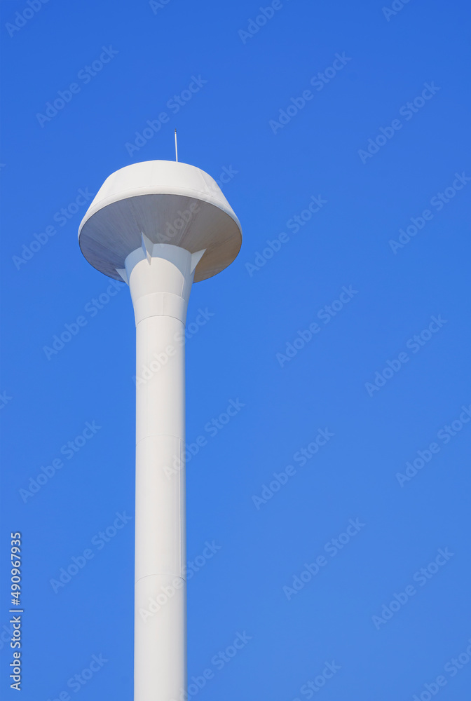 White champagne tower tank against blue clear sky in vertical frame White champagne tower tank against blue clear sky in vertical frame