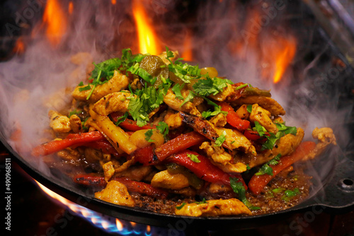 mexican traditional food, chicken fajitas served on a hot smoking sizzling plate photo
