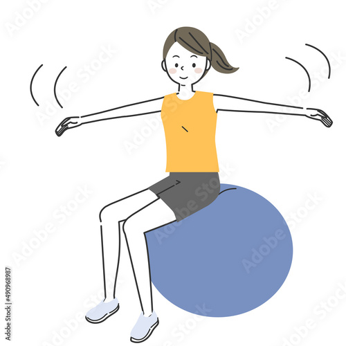 バランスボールに乗ってトレーニングをする女性