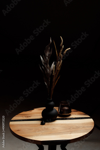 Expensive vintage furniture. The table is covered with epoxy resin and varnished. Luxury quality wood processing. Acrylic crystals in the decor. A bouquet of dried flowers in a minimalistic black vase