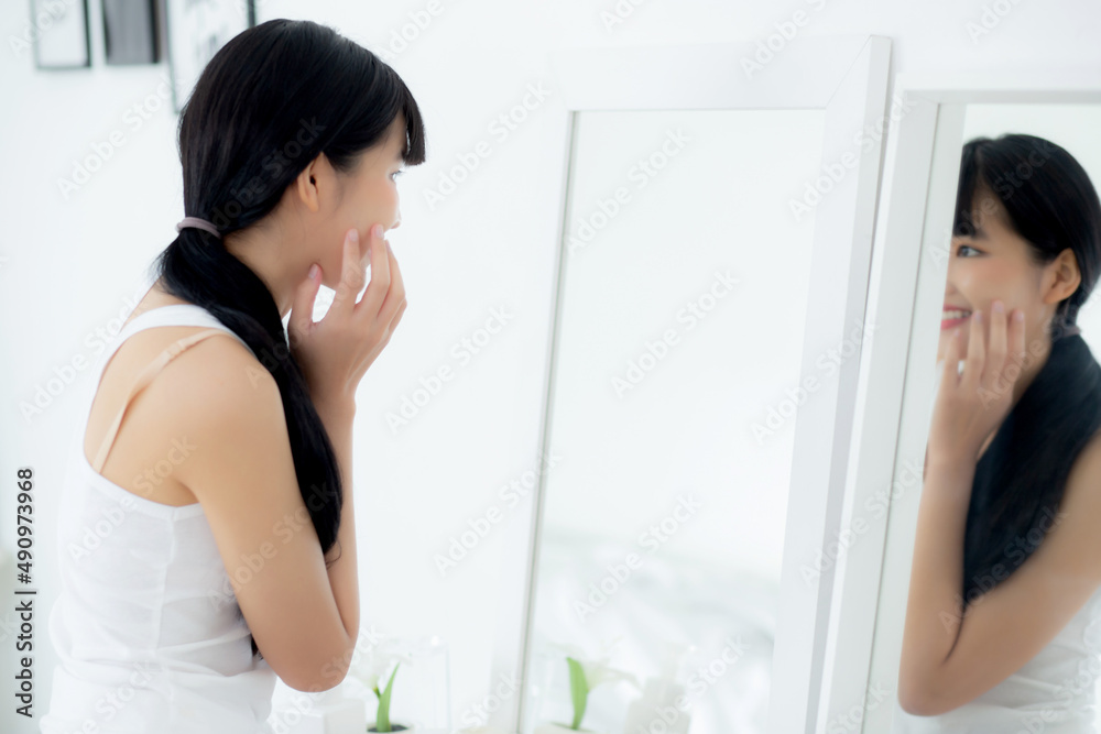 Beautiful face of young asian woman with happy smiling and touch cheek looking mirror with charming, makeup of beauty facial girl with skincare and cosmetic treatment, skin care and healthy concept. Beautiful face of young asian woman with happy smiling and touch cheek looking mirror with charming, makeup of beauty facial girl with skincare and cosmetic treatment, skin care and healthy concept.
