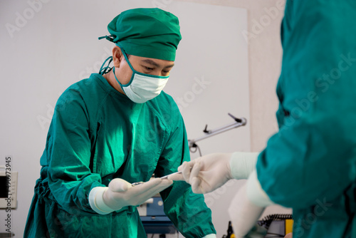 Doctor sending instrument with surgeon with rescue and save patient in the operation room at hospital, surgery and emergency, medical and technology, surgical and health, specialist and assistant.