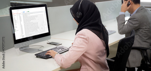 Young businesswoman is muslim or islam and team wearing headphone with diversity ethnicity while call center support customer service and check email on computer at the office, business concept.