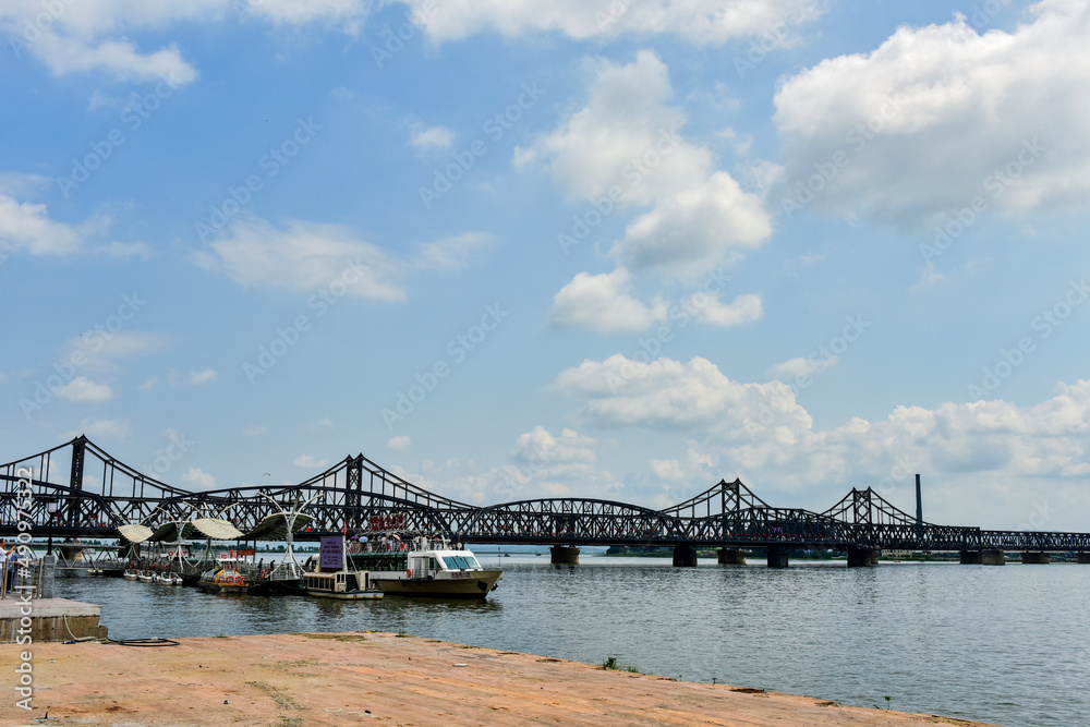 Dandong City, Liaoning Province, China - August 17, 2019: the urban landscape of Dandong City and the Korean landscape across the Yalu River Dandong City, Liaoning Province, China - August 17, 2019: the urban landscape of Dandong City and the Korean landscape across the Yalu River