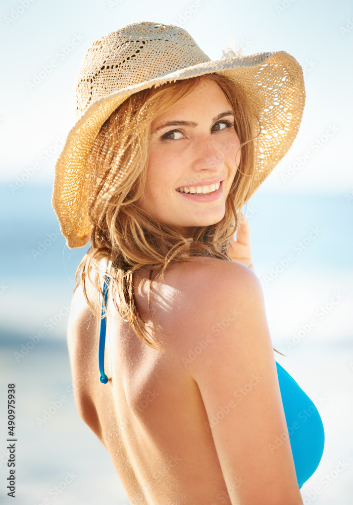 Making the best of a lovely day. Shot of a gorgeous young woman in a blue bikini at the beach.