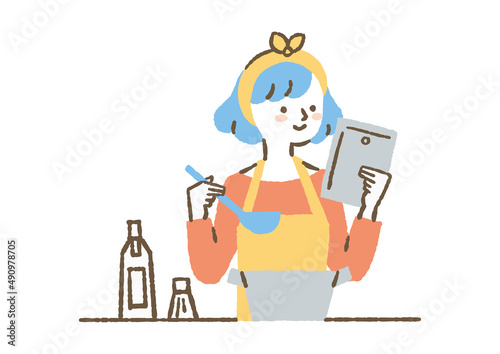 タブレットを見ながら料理する女性_色