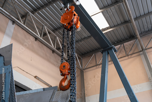 The construction crane in factory. chain hoist hanging on steel box photo