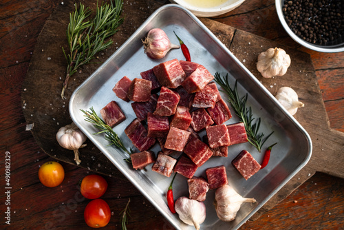Sliced grilled thai steak served on white plate with grilled sliced lemon, tomatoes, garlic