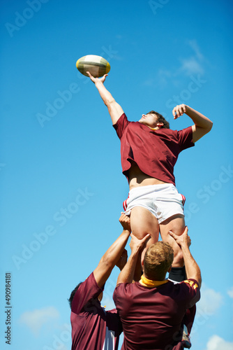 Capturing an epic moment. Shot of a young rugby player catching the ball during a lineout. photo