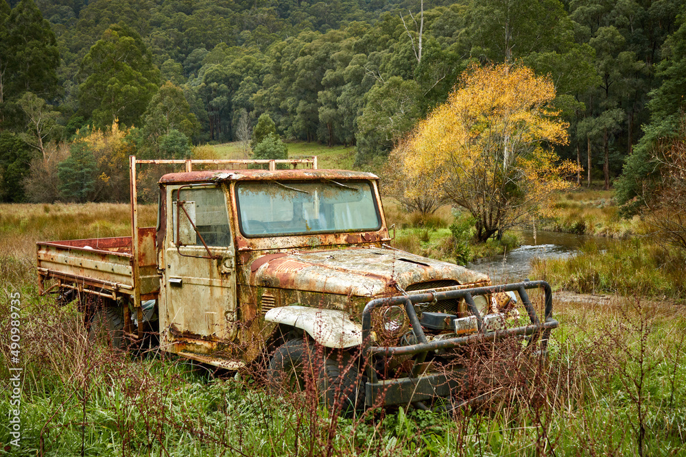 Old vehicle abandoned in the Australia bush near a stream trees and grassland Old vehicle abandoned in the Australia bush near a stream trees and grassland