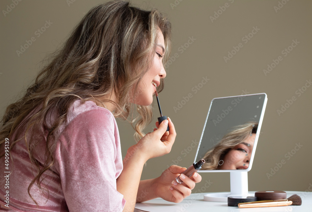 beautiful asian girl is doing makeup to herself in front of a mirror beautiful asian girl is doing makeup to herself in front of a mirror
