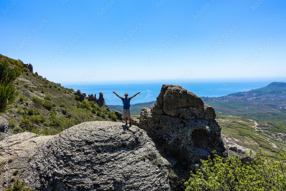 A man on the background of the plateau of the Crimean mountains and the Black Sea from the top of Demerji. Russia.