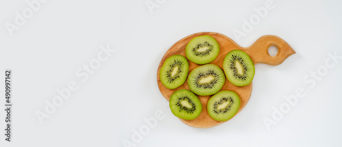 kiwi slices on a decorative wooden stand on a light background, banner