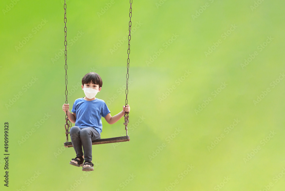 Portrait of Asian child sitting on swing happy on natural green background. children having fun on summer vacation dreams and imagination Portrait of Asian child sitting on swing happy on natural green background. children having fun on summer vacation dreams and imagination