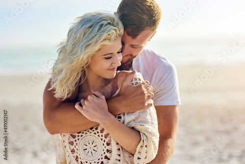 You deserve to escape every once a while. Cropped shot of n affectionate couple spending the day at the beach. photo