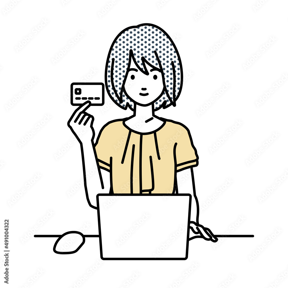 デスクで座ってPCを使いながらクレジットカードを手に持っているオフィスカジュアルの女性