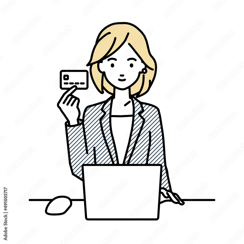 デスクで座ってPCを使いながらクレジットカードを手に持っているスーツの女性