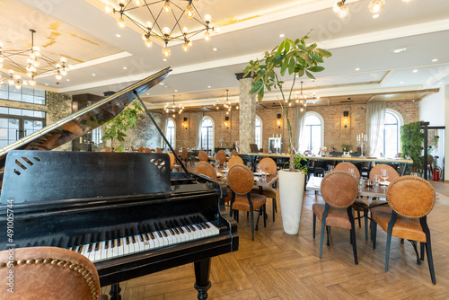 Interior of a modern hotel cafe restaurant with old rustic piano photo