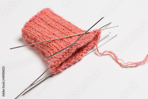 The knitting project is under implementation. Knitting needles on a white background