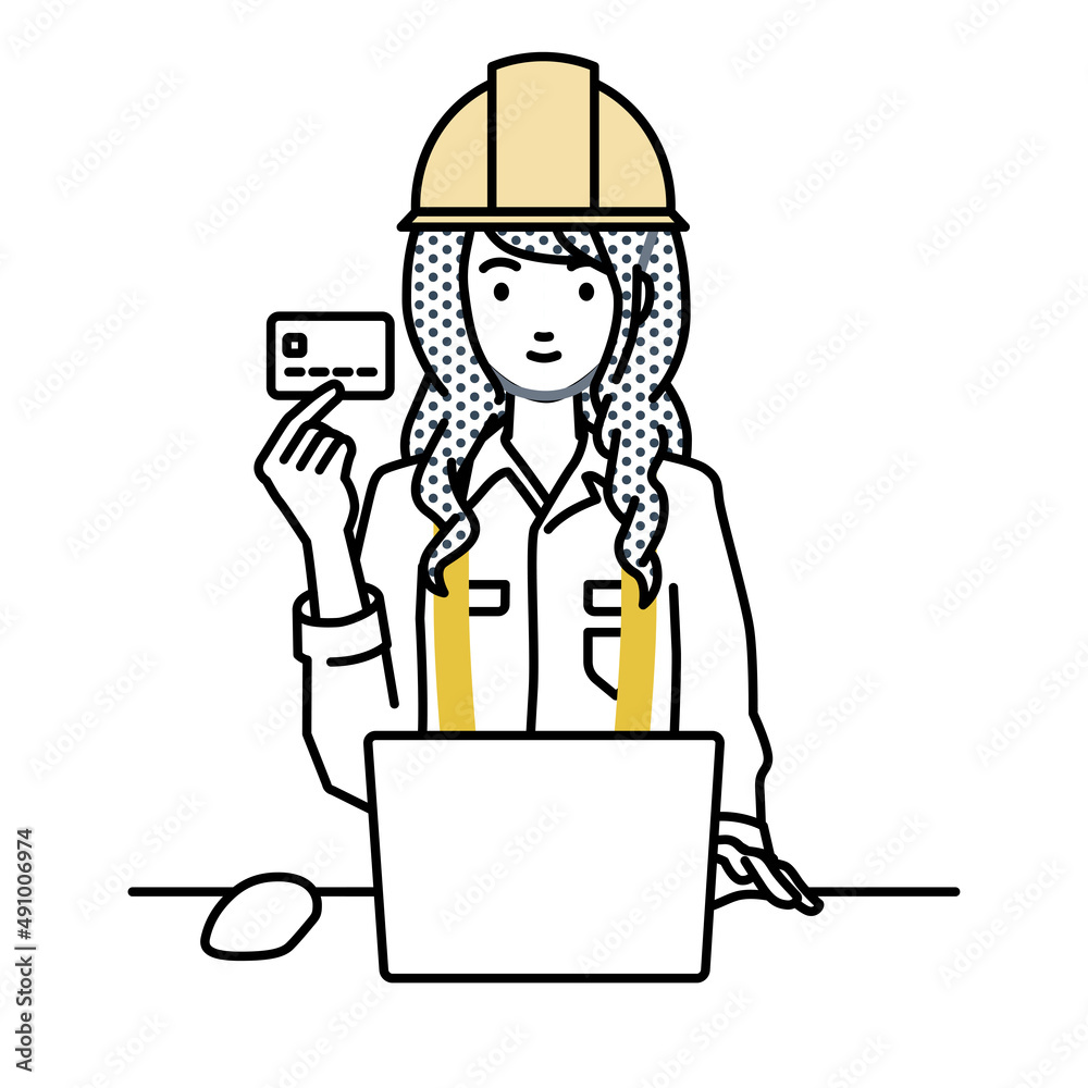 デスクで座ってPCを使いながらクレジットカードを手に持っている工事現場の女性
