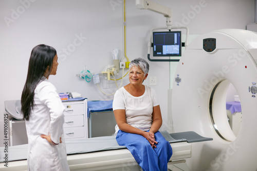 Let me explain how this works.... Shot of a senior woman talking with a doctor before and MRI scan.