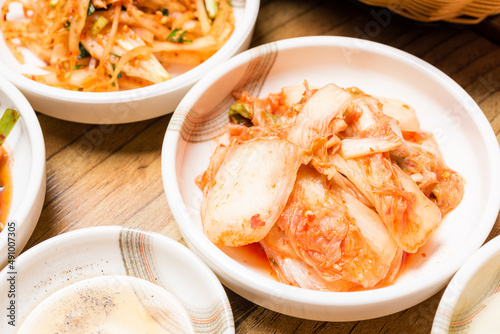 Spicy Kimchi. Korean pickle or Pickled radish vegetables and seasoning on bowl on wood table background, Japanese food