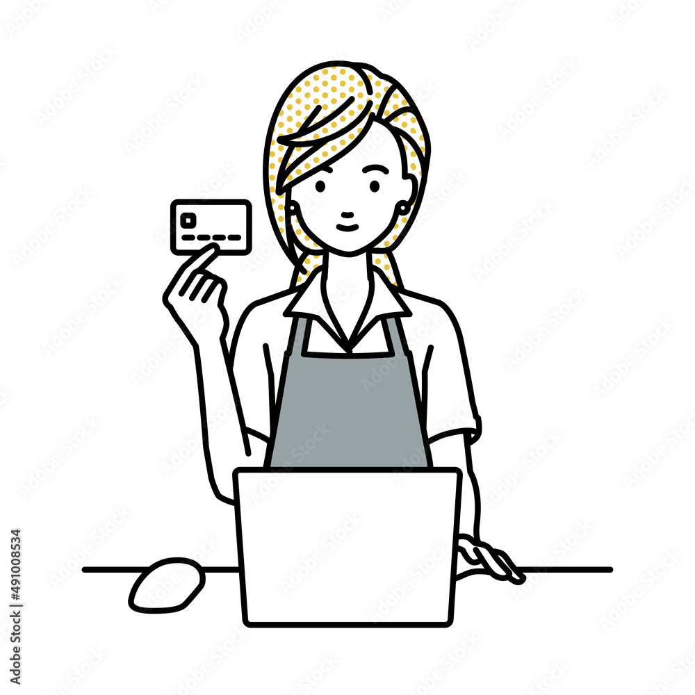 デスクで座ってPCを使いながらクレジットカードを手に持っているカフェ店員の女性