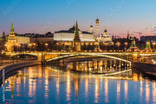 Illuminated Moscow Kremlin and Bolshoy Kamenny Bridge in the night. View from the Patriarshy pedestrian Bridge in Russia. Evening urban landscape in the blue hour