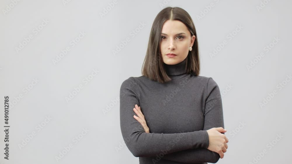 Serious caucasian woman in grey turtle neck bodycon dress, women power, monochromatic concept. Middle shot Serious caucasian woman in grey turtle neck bodycon dress, women power, monochromatic concept. Middle shot