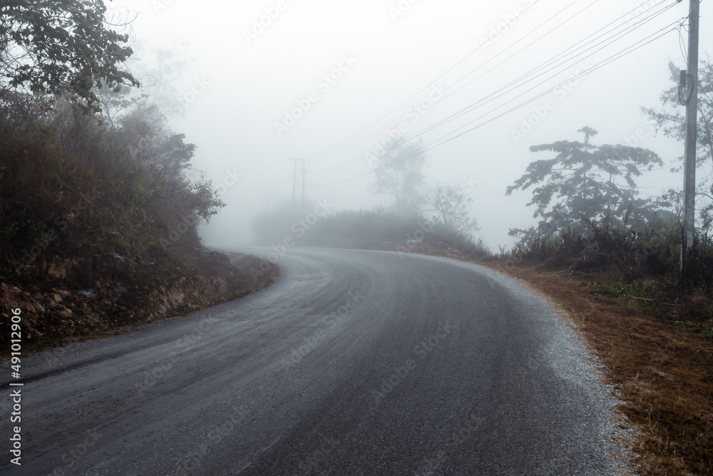 Asphalt road in a fog in the mountains Asphalt road in a fog in the mountains