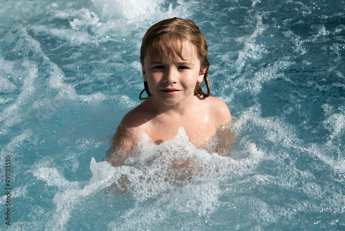 Smiling cute little boy in swimming pool.