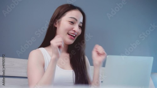 Attractive young asian business woman using laptop while shopping online on the bed at home. Lesbian couples relationship and travel concept for stock footage.
