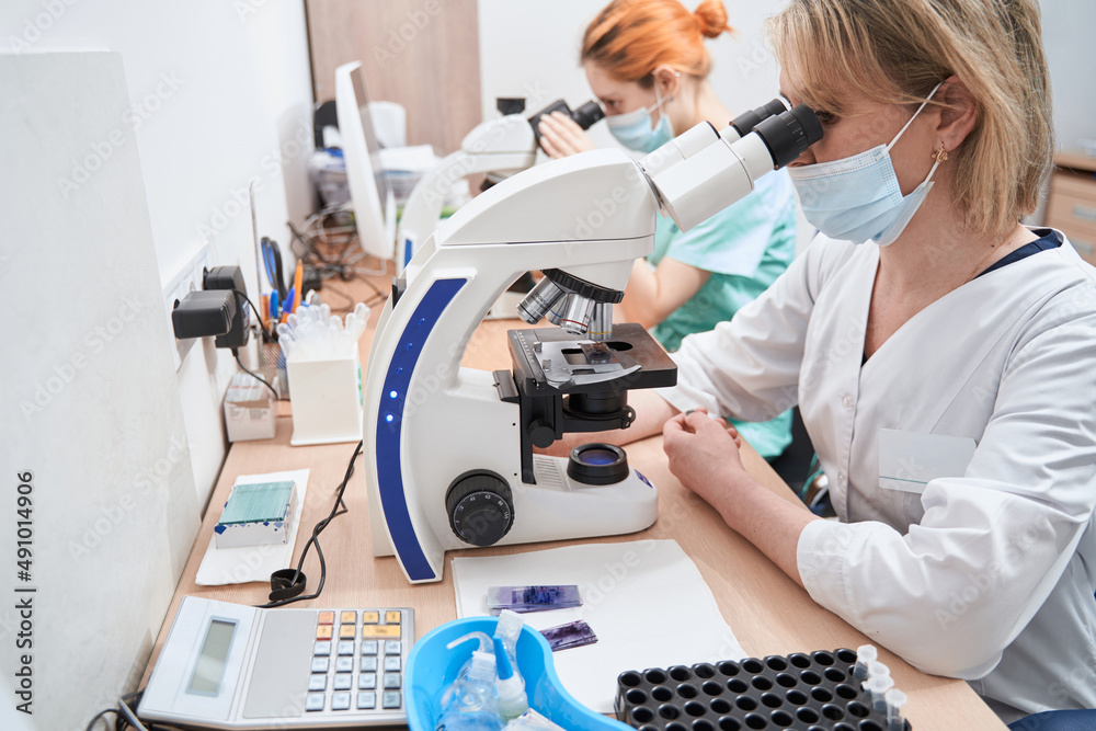 Medical workers in the laboratory with microscopes Medical workers in the laboratory with microscopes